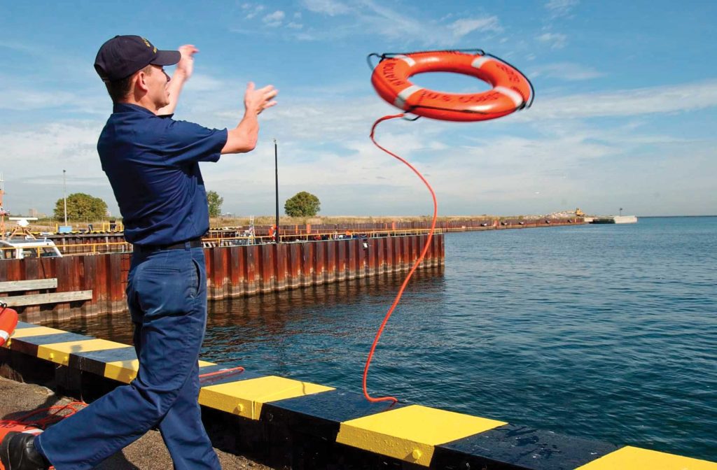Coast Guard crew member throwing PFD
