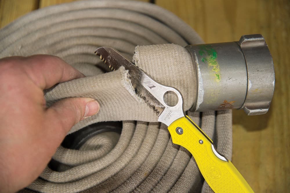 a knife cutting a hose