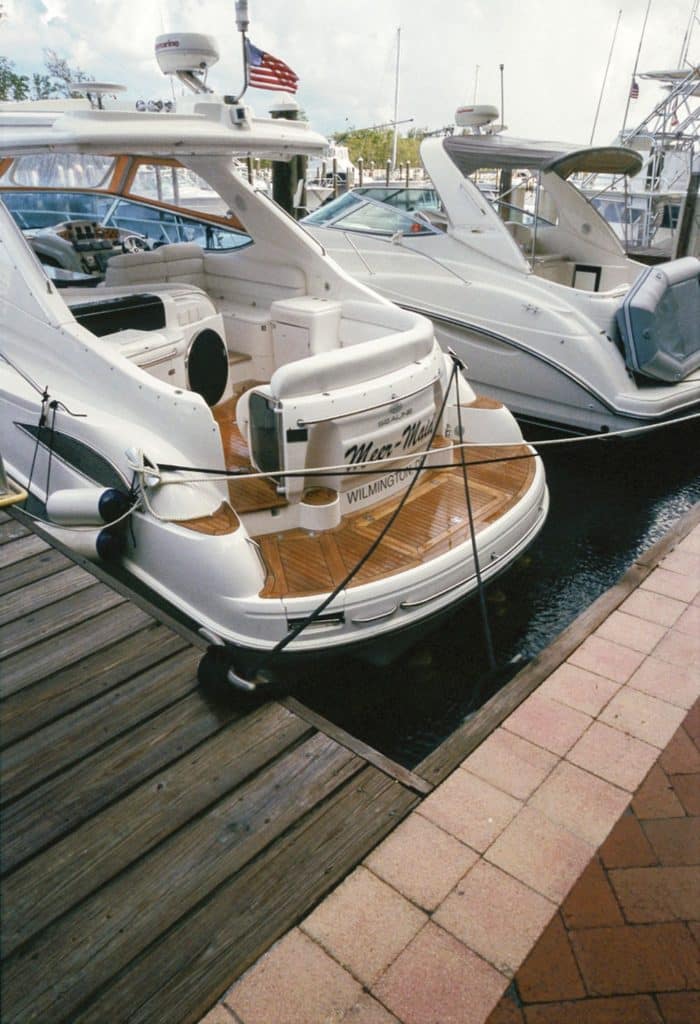 A sport-fishing boat docked and secured at a marina