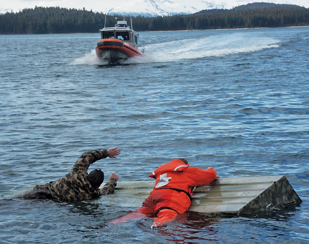 two people overboard near a rescue boat.