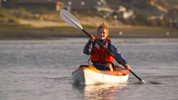 A person paddling a canoe on the water.