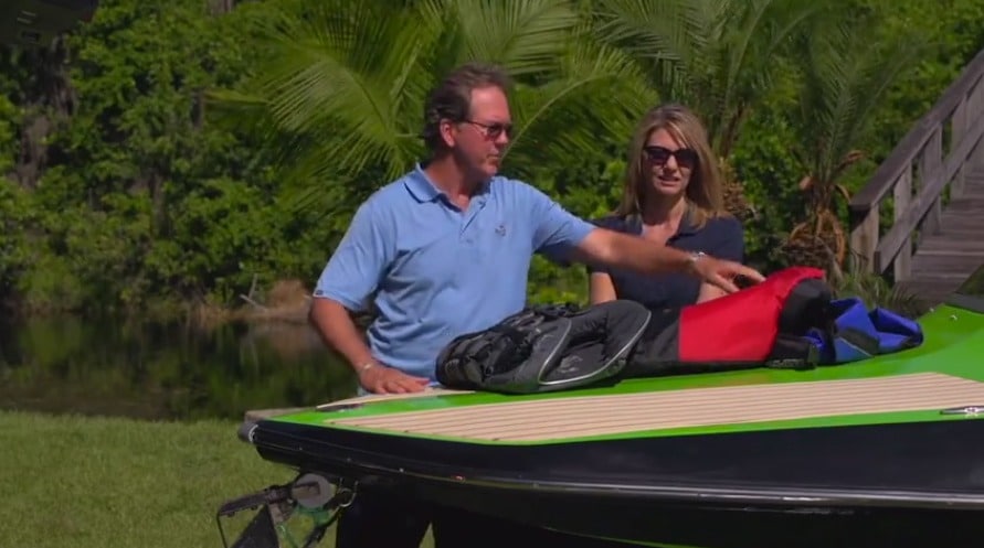 A man and woman check over a boat carriage.