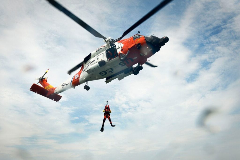 Coast Guard rescue swimmer jumping out of helicopter