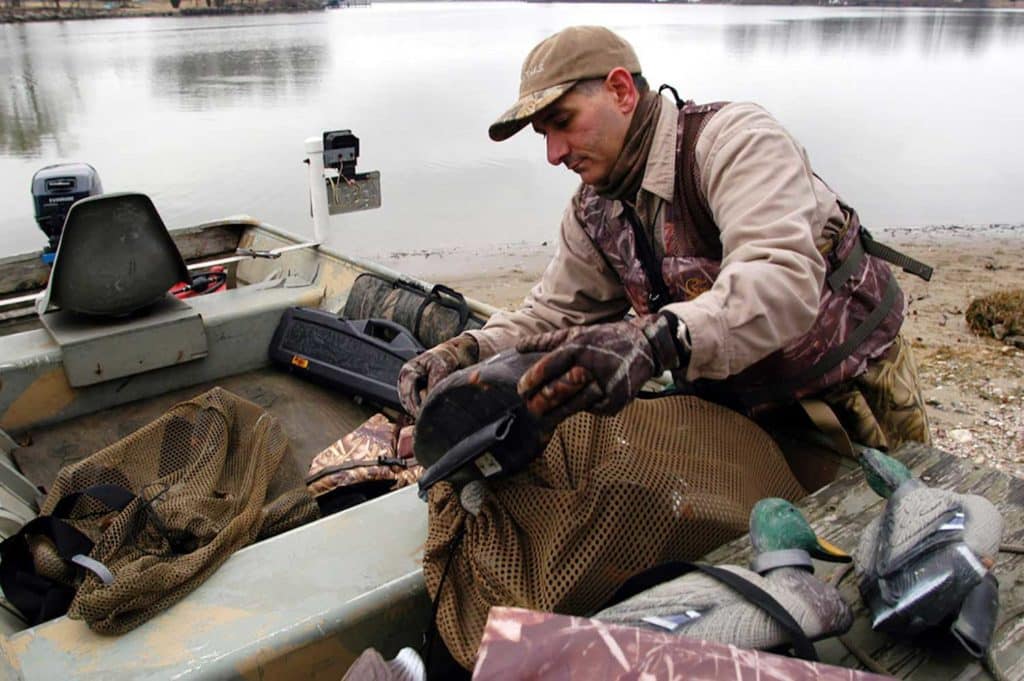 Hunter putting gear in a boat