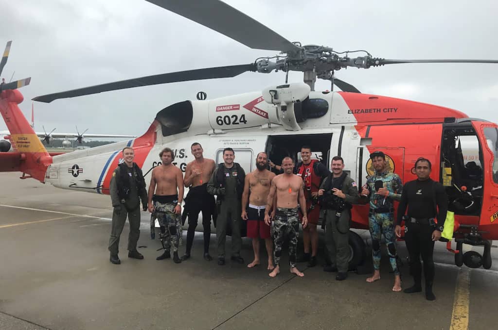 Coast Guard helicopter crew with rescued fishermen