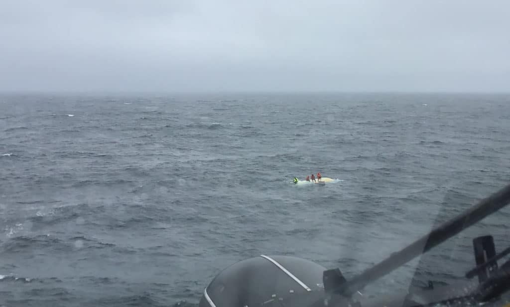 Coast Guard helicopter approaches overturned boat